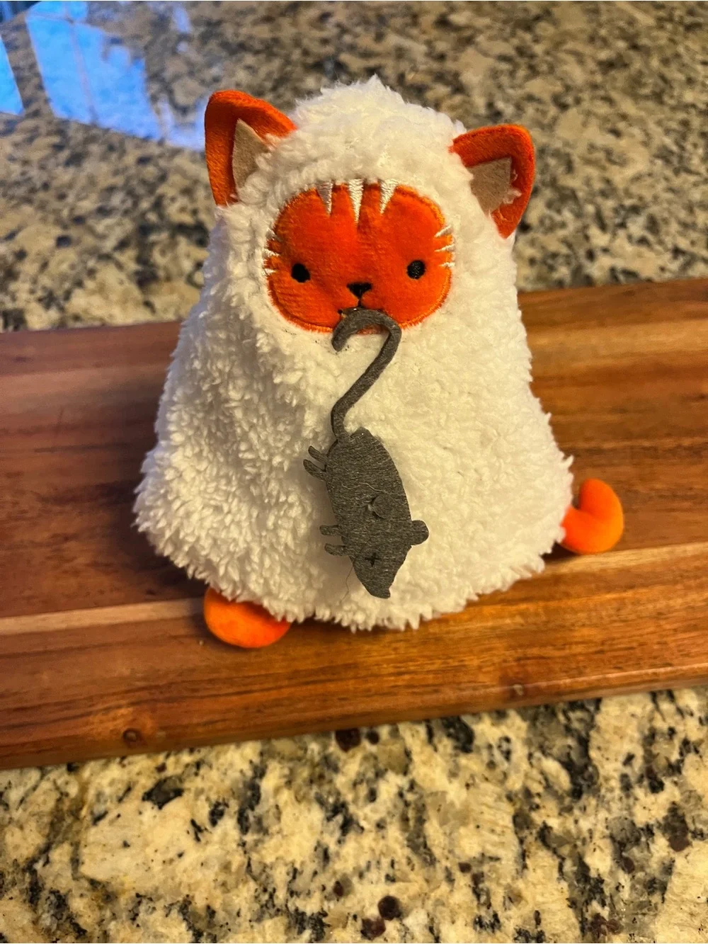 Plush soft small Cat disguised as a ghost costume showing off its mouse catch